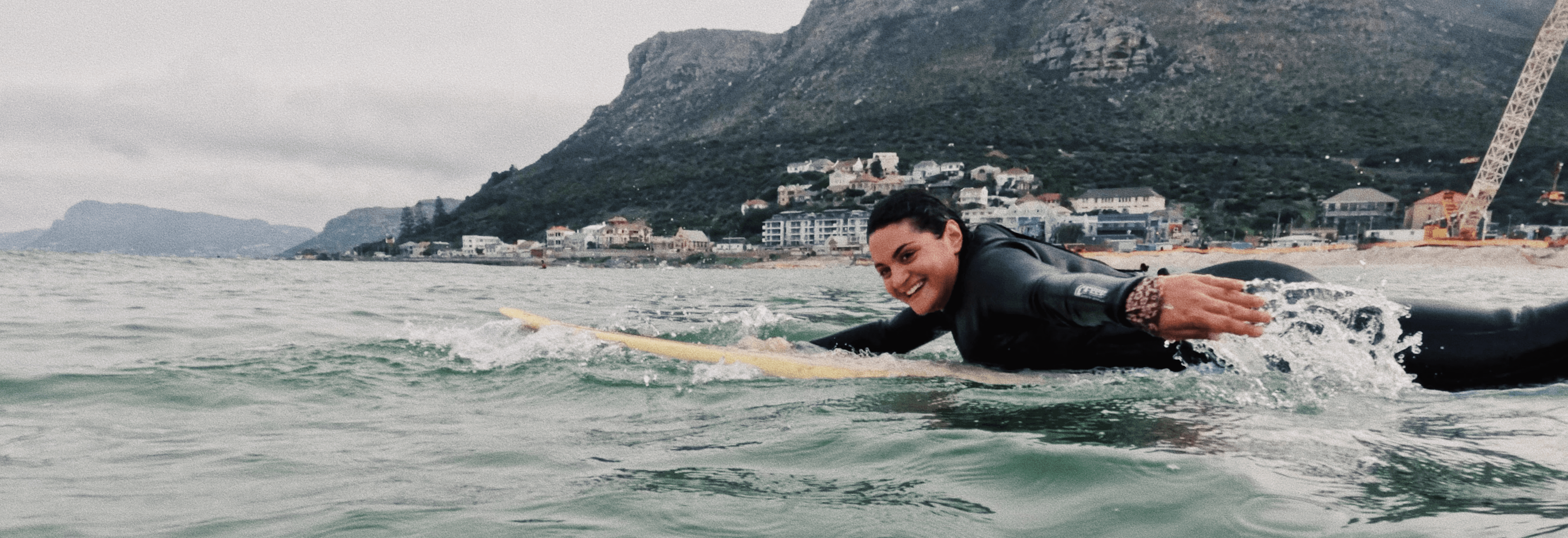 A female surfer surfs in the water during her surf lesson in Cape Town, Muizenberg. Eine weibliche surferin während ihres Surfunterrichts in Kapdstadt, Muizenberg