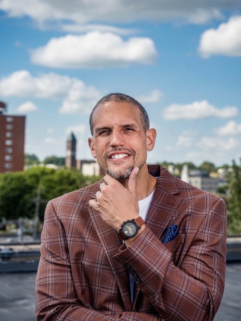 a man in a blue shirt smiling at the camera