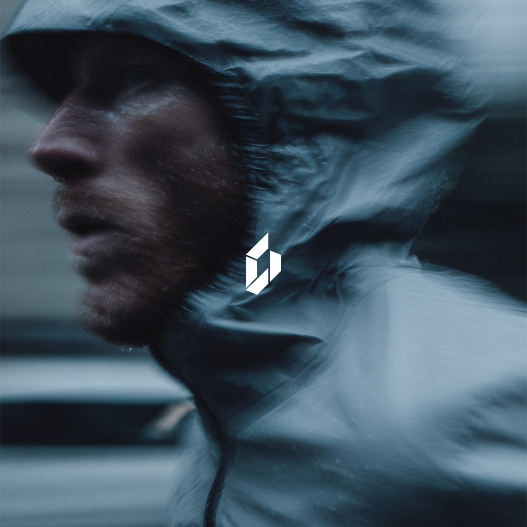 man wearing grey t-shirt standing in front of man sitting on chair