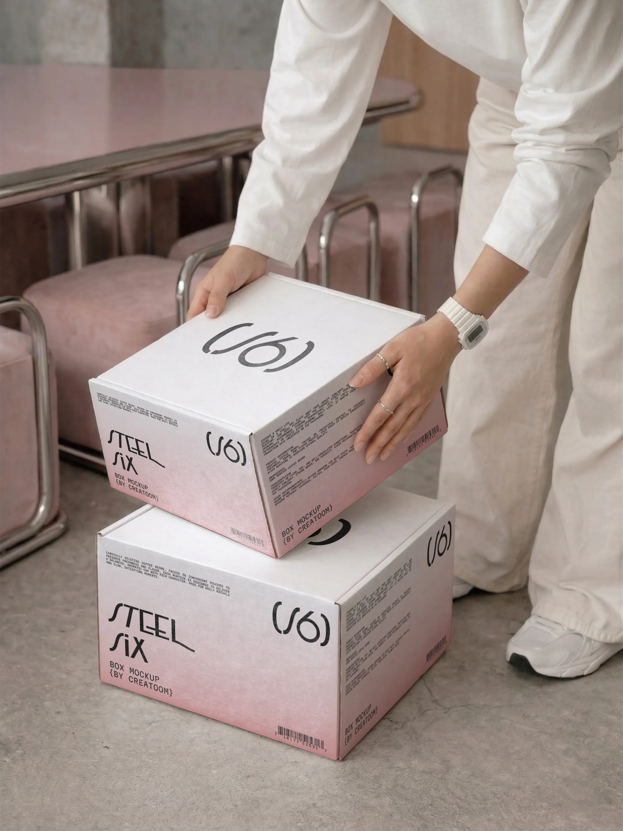 Person stacking two white and pink branded delivery boxes