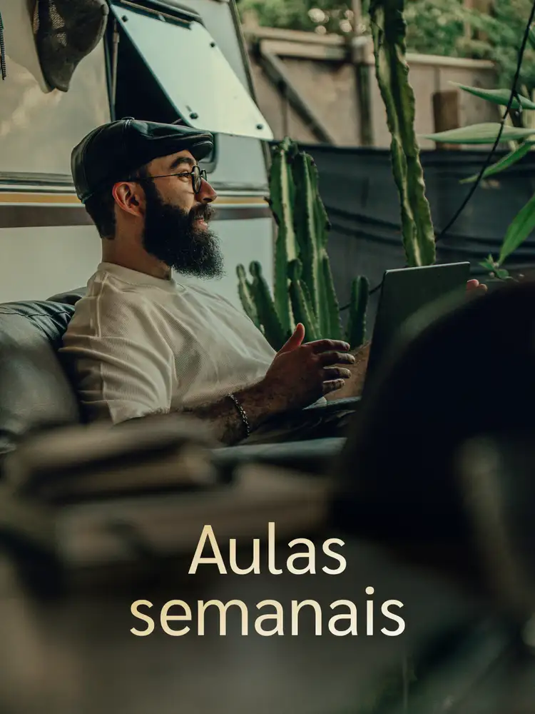 Vineyard rows under leafy foreground frame a Tuscan villa on a misty hill
