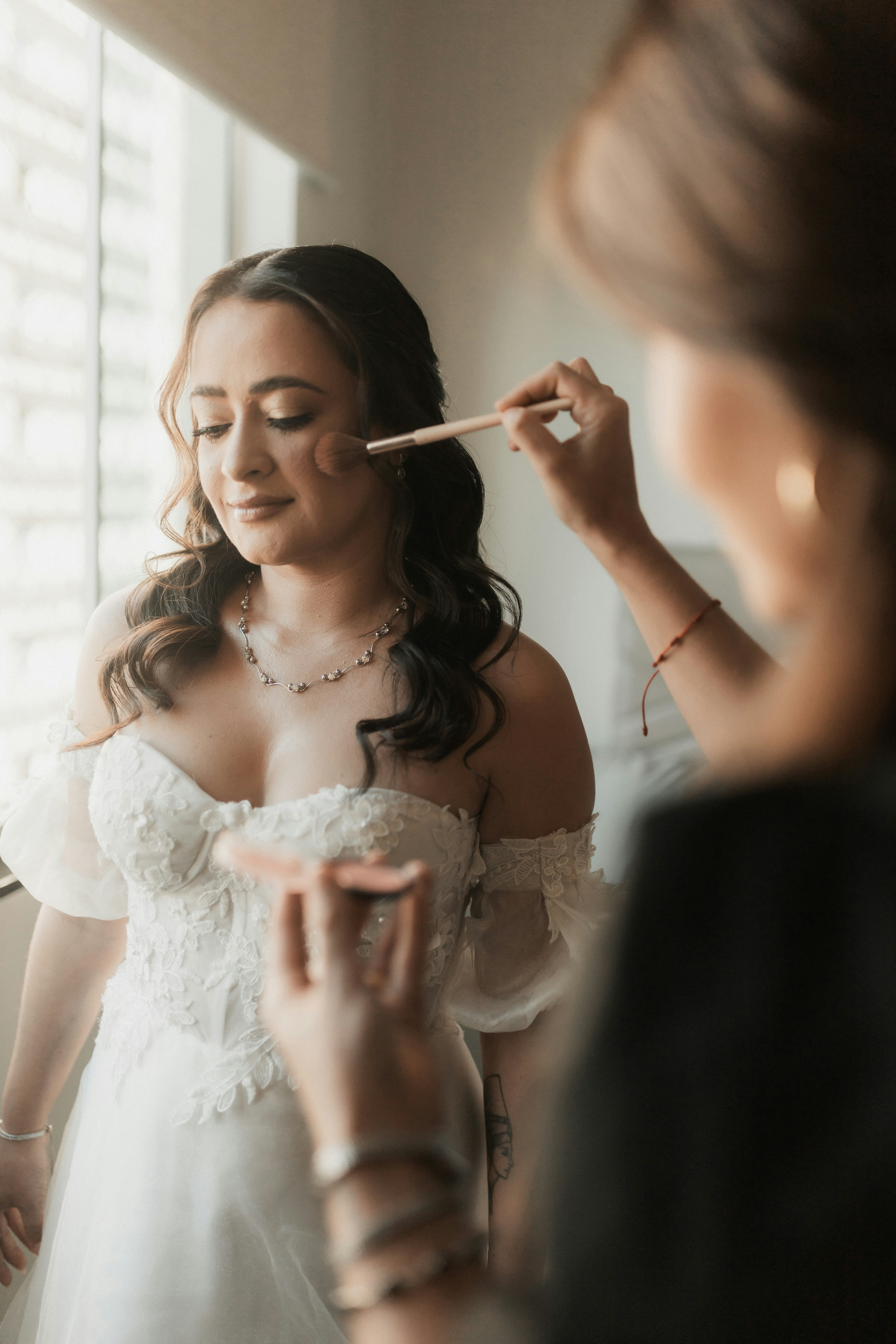 A bride is getting her makeup done.