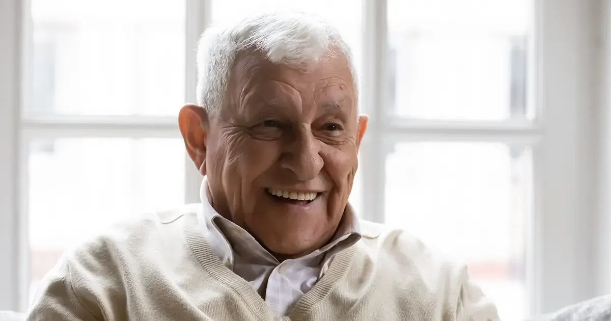 Bilde av en glad, eldre mann.