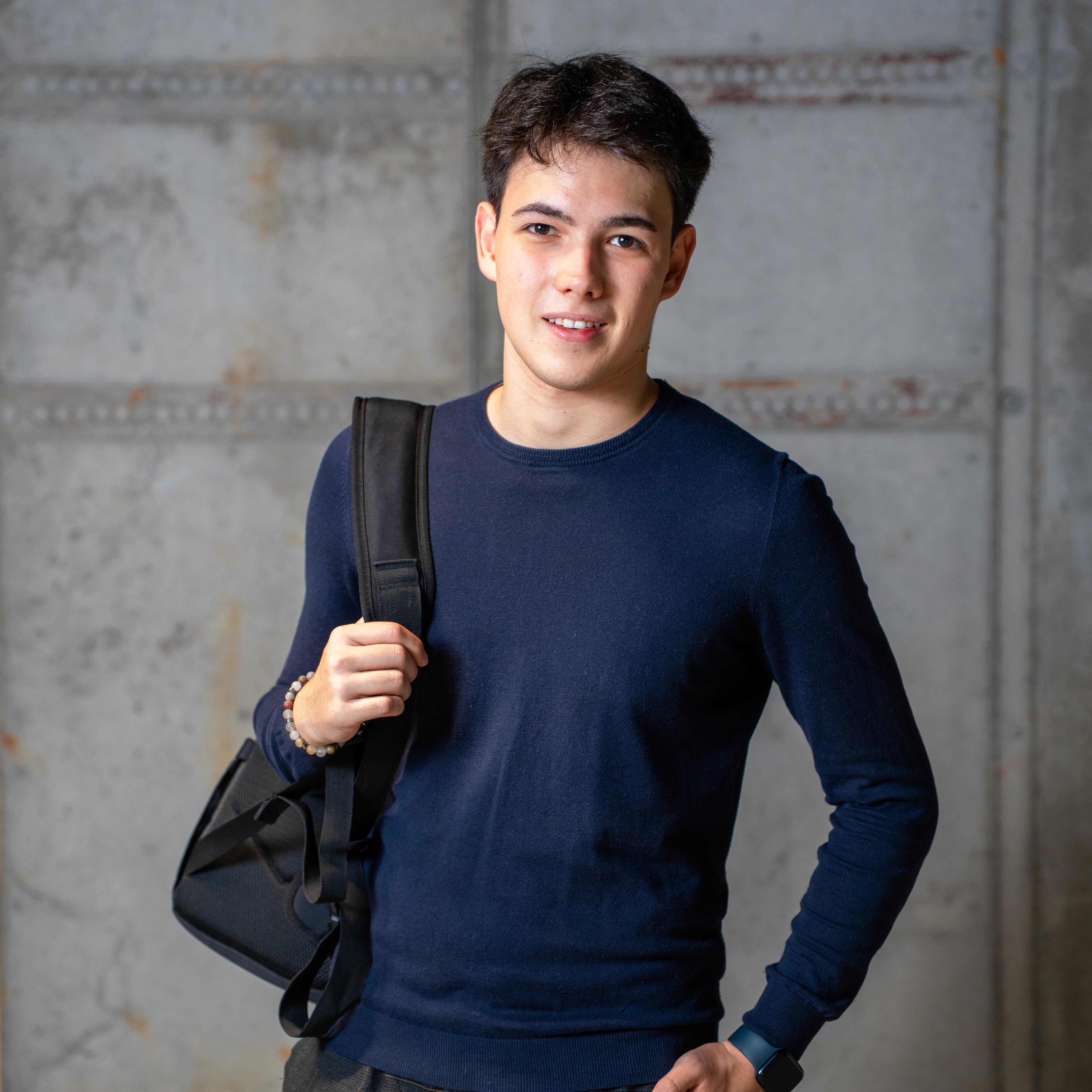Close-up of a dark green leaf showing its textured surface and central vein against a muted background.