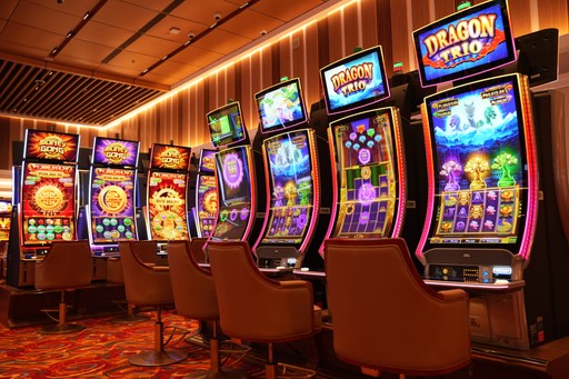 Three stylish Asian friends taking a selfie together inside a glamorous casino, bright slot machines in the background, warm lighting, energetic smiles, atmosphere full of excitement — editorial photography style.