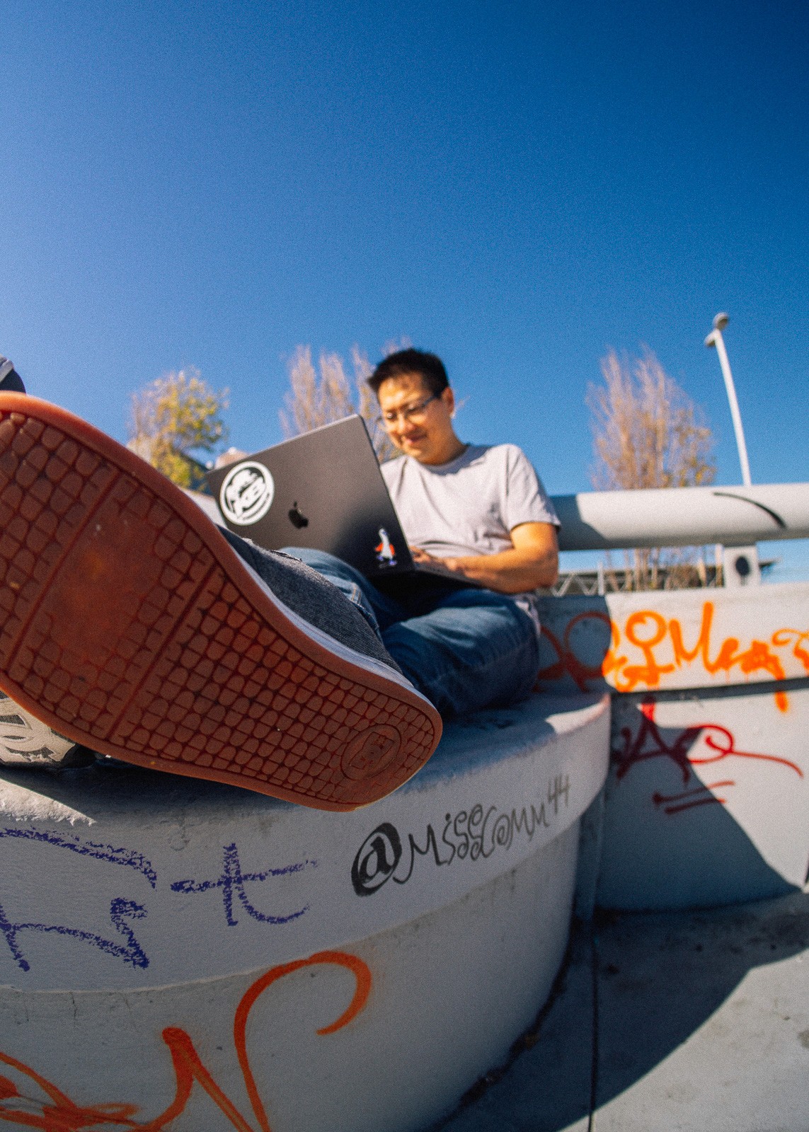 David, founding engineer, working on a laptop outdoors in a skatepark