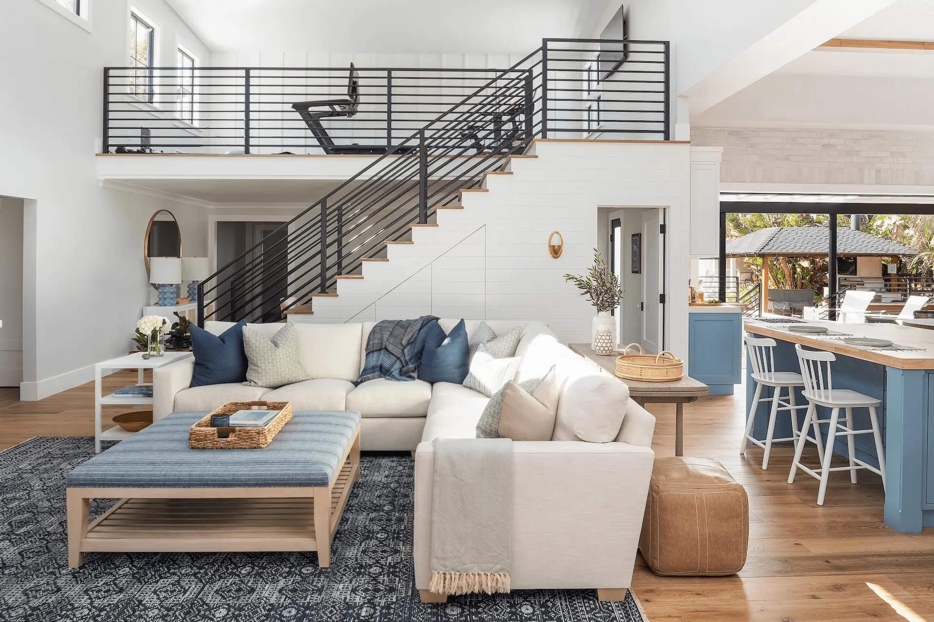Stylish great room with modern staircase and open kitchen in North Tustin Remodel & Addition. Photo by Molly Rose.