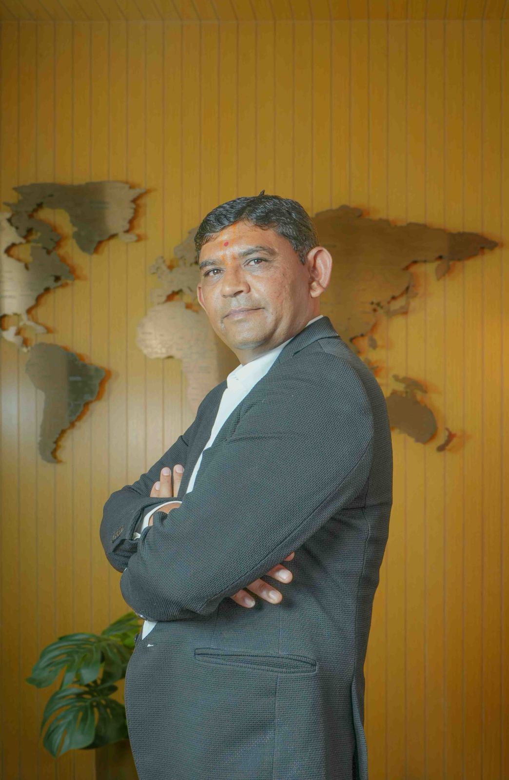 A man in a suit sits at a desk.