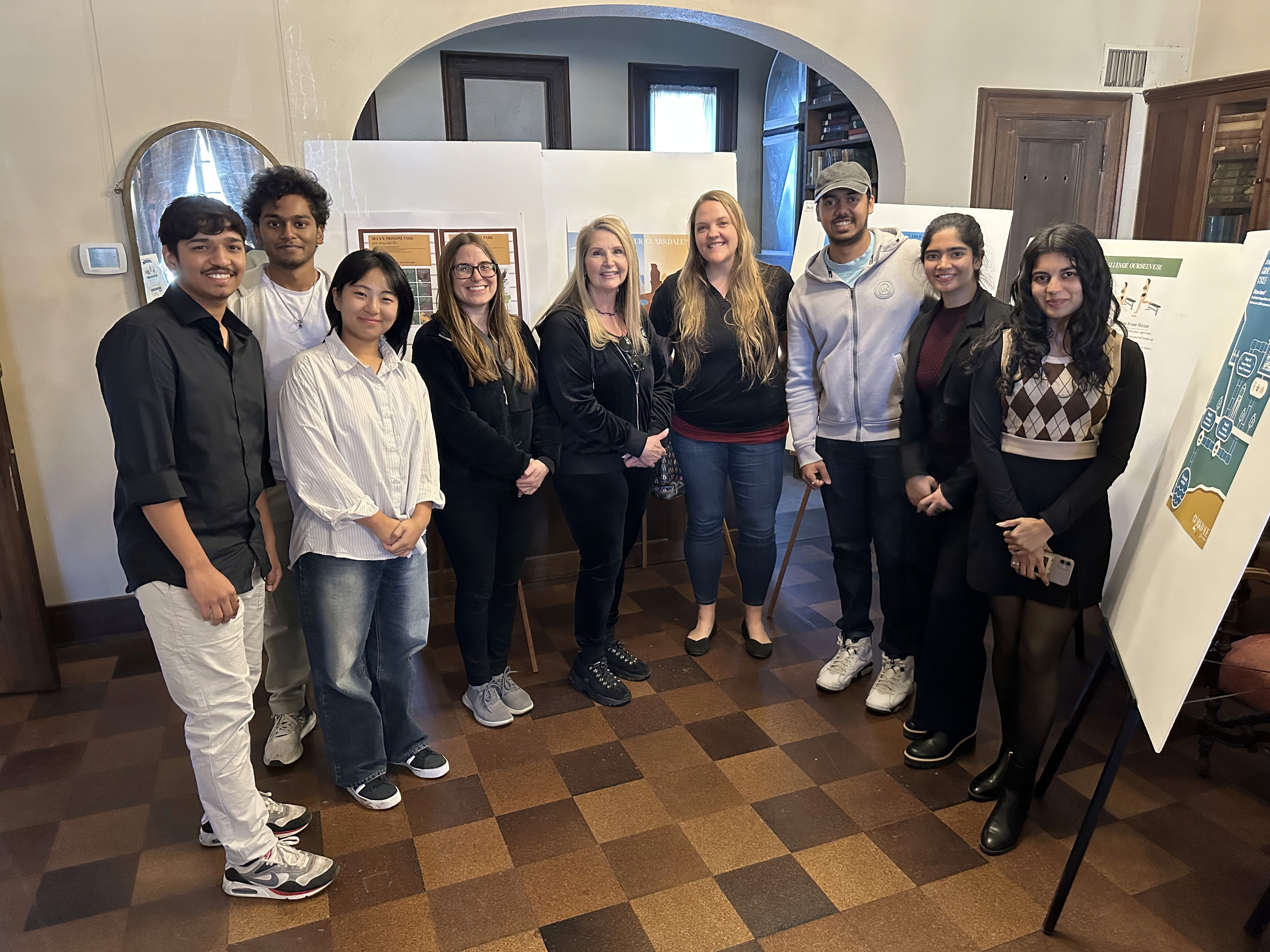Atharva with the project cohort and town staff in front of the boards on easels
