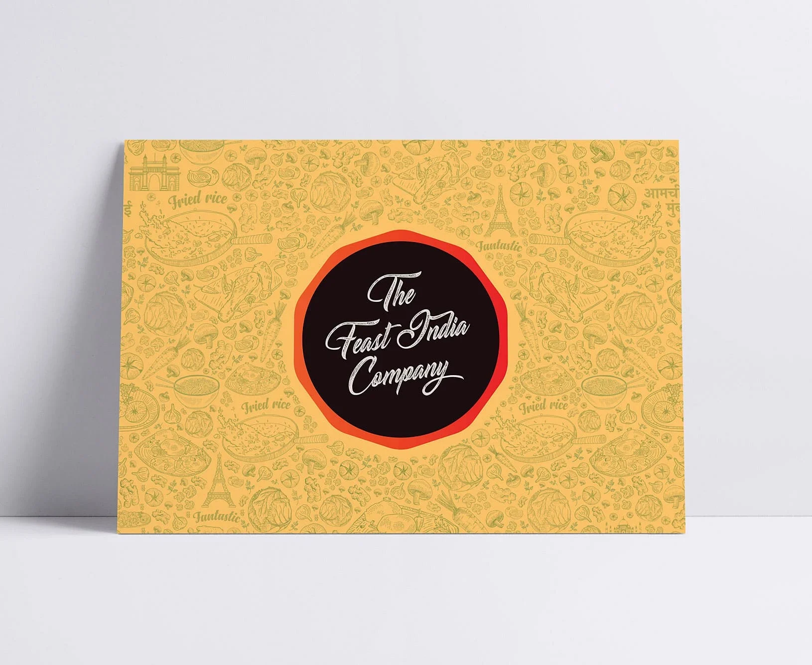 Yellow vintage-style food packaging with ornate illustrations and a central black-and-red logo reading “The Feast India Company,” evoking warmth.
