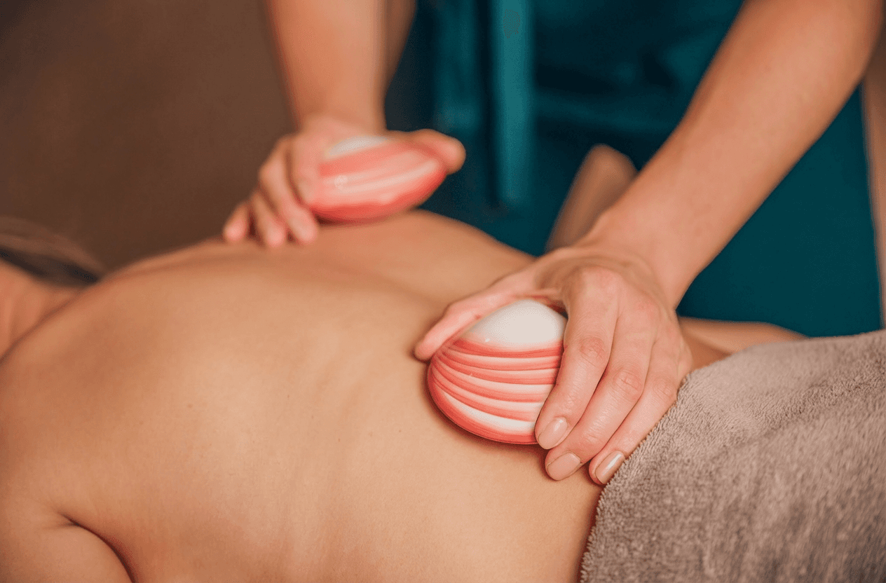 Een vrouw geniet van een warme schelpen massage in Efluo Mechelen