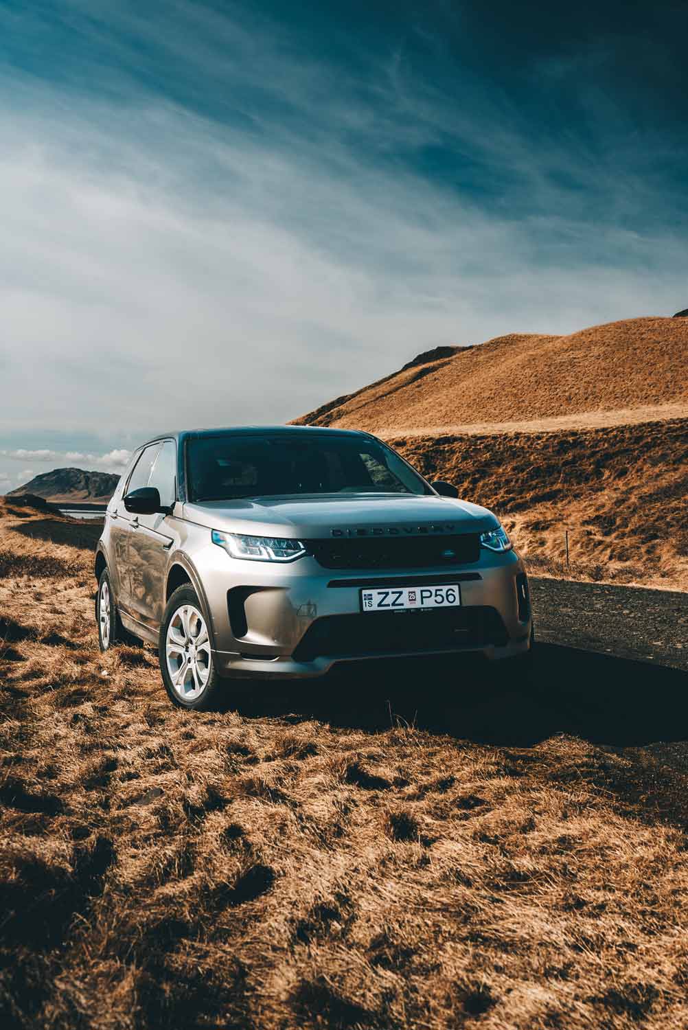 Silver SUV on scenic road; captured for a landcover ad.