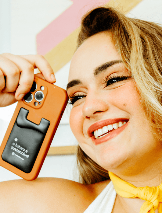 Mulher sorrindo feliz com o celular na mão