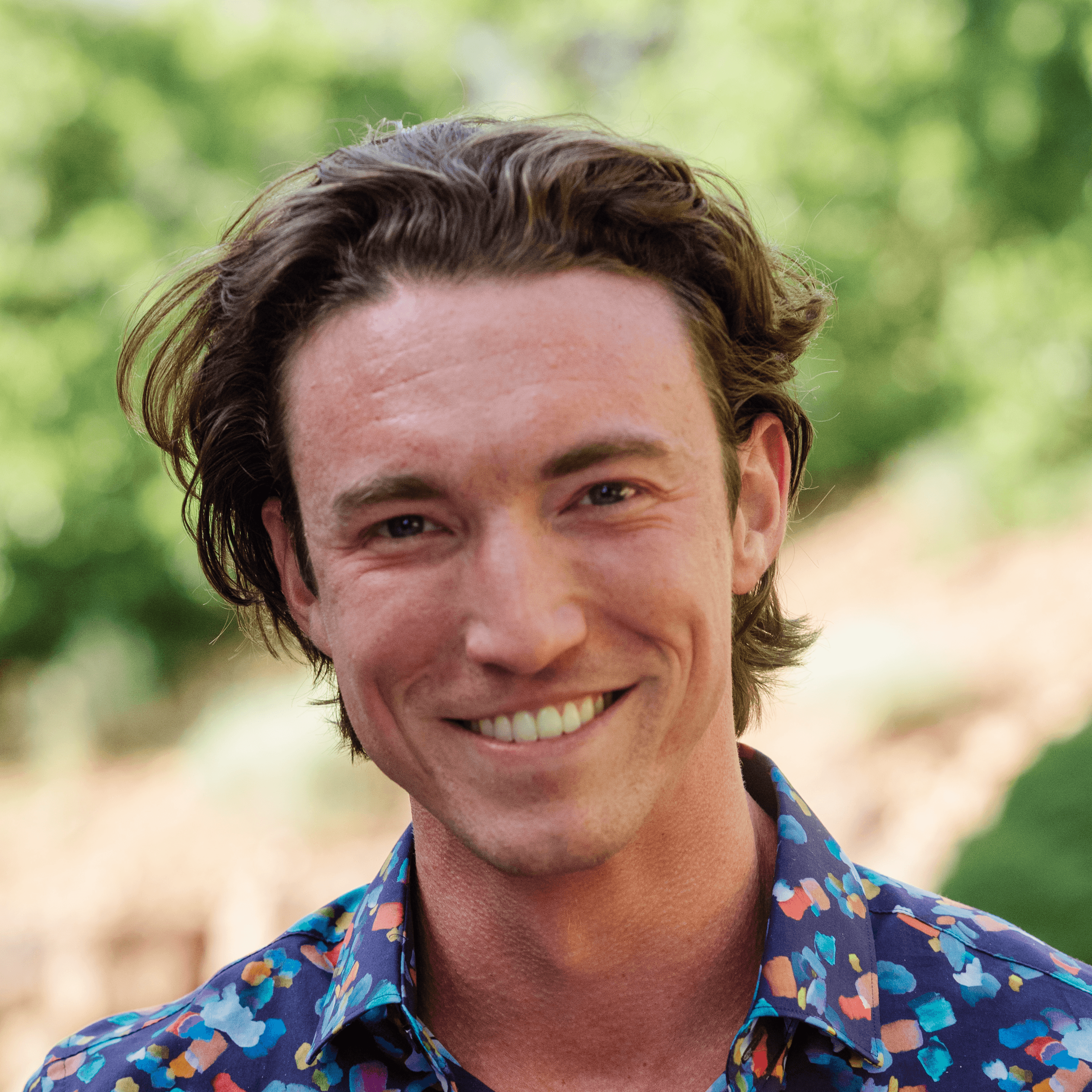Profile portrait of a man in a white shirt against a light background