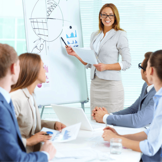 Female executive leading a board meeting: executive presentation skills and strategic communication workshops for leaders.