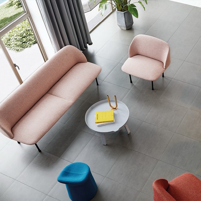 Modern minimalist furniture set in a top-down view, showcasing a blush pink upholstered sofa, matching lounge chair, and a circular gray coffee table. Ideal for contemporary home decor and open-plan living room inspiration.
