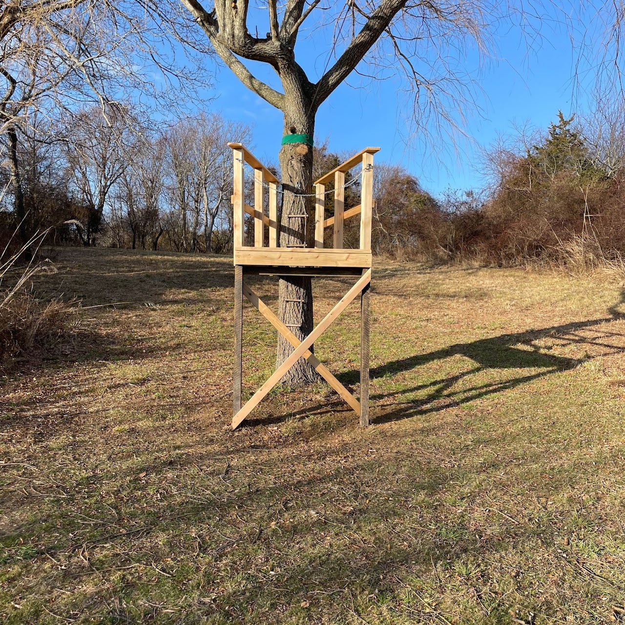 Custom wood tree-mounted stand platform in open field