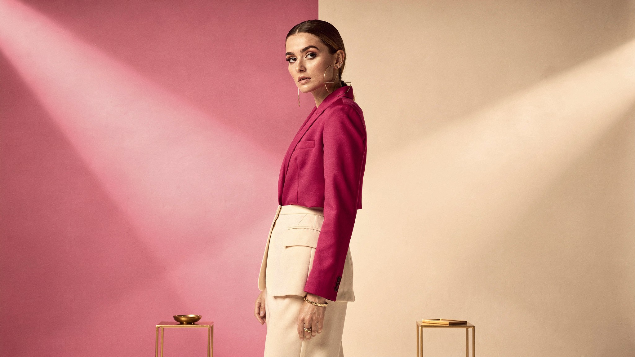 Creator standing at a crossroads moment deciding between two verification paths in a pink studio
