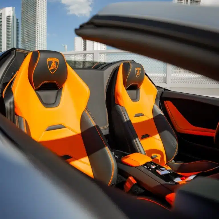 Detailed view of the luxurious orange and black two-tone sport seats in the Lamborghini Huracán EVO Spyder's interior.
