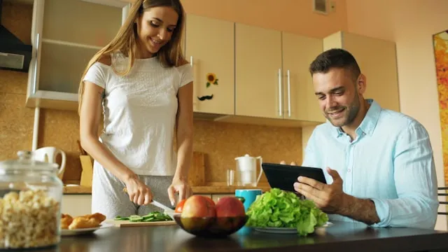 Woman reviewing nutrition data in a kitchen with a glucose tracking card overlay