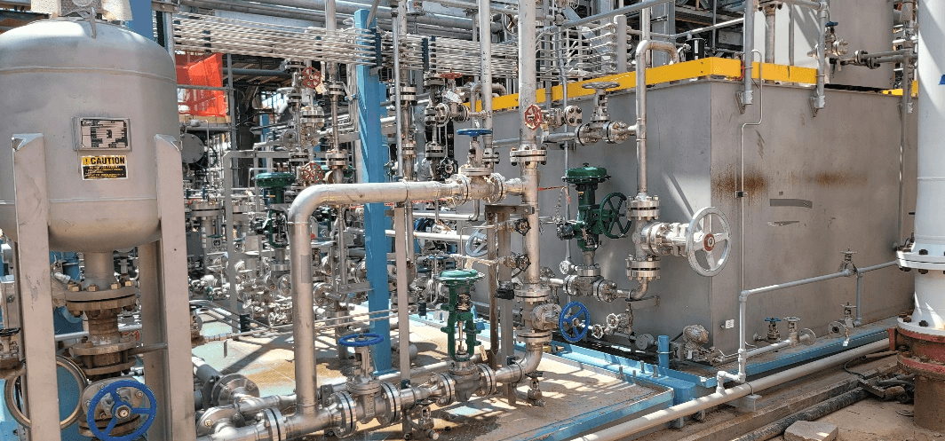 Large cylindrical storage tanks and pressure vessels in an industrial plant setting