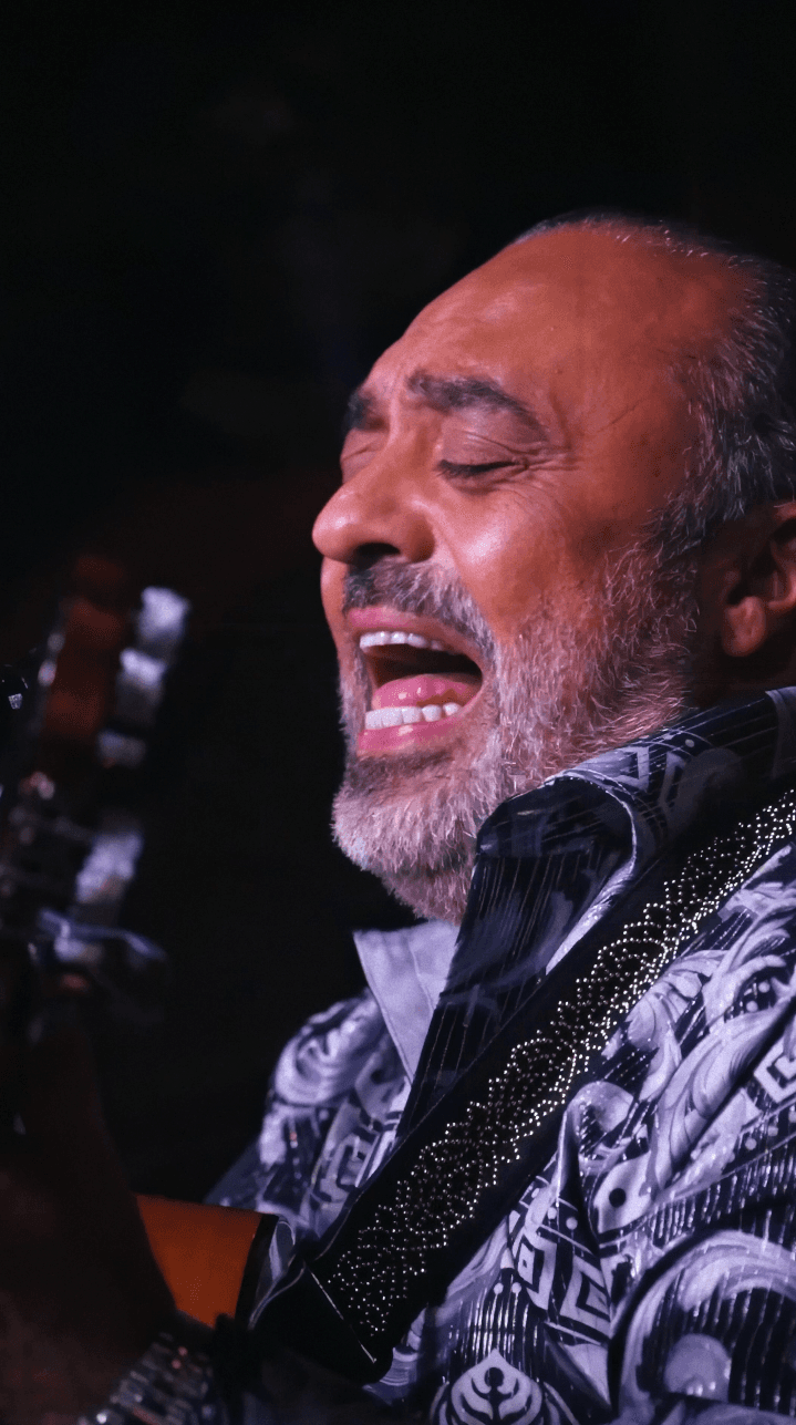 Woman in black outfit posing with arms raised
