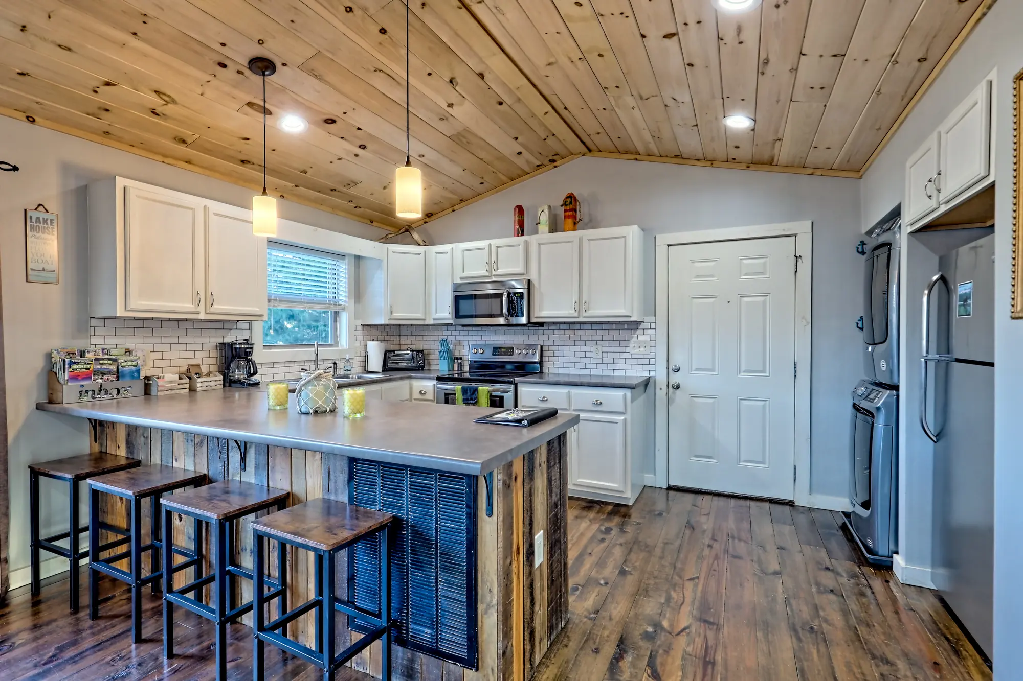 Eagles Landing kitchen island with four bar stools and white cabinets