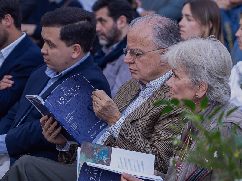 Grupo de siete expositores e invitados posando en el escenario durante el evento de lanzamiento de la edición número 9 de la Revista Raíces de IdeaPaís.