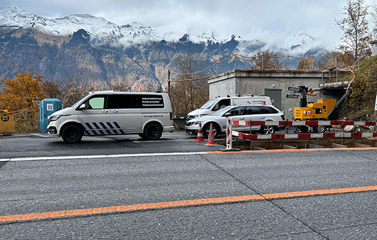 Four diverse professionals collaboratively working on a laptop, with one person pointing at the screen while others observe.