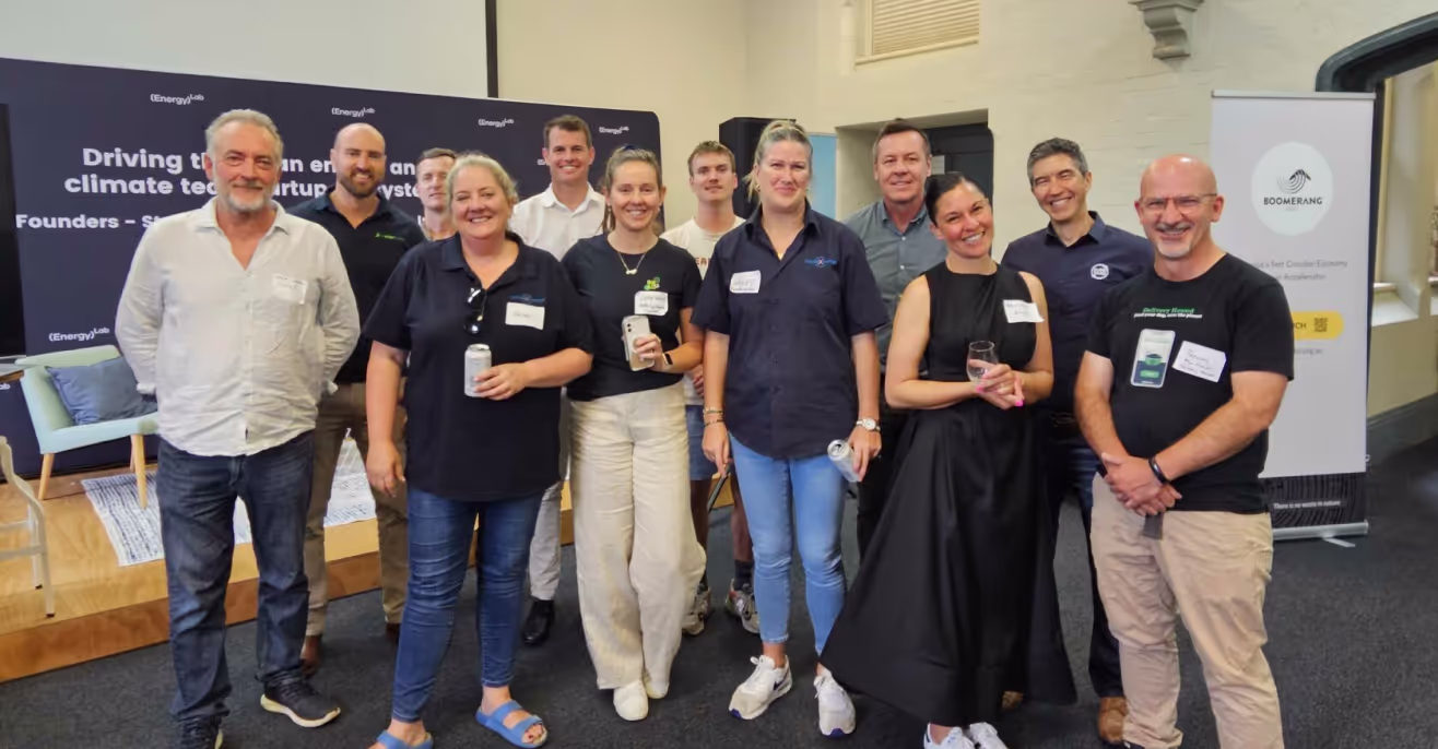 A group of founders and mentors standing together at a Boomerang Labs accelerator event in front of a branded banner