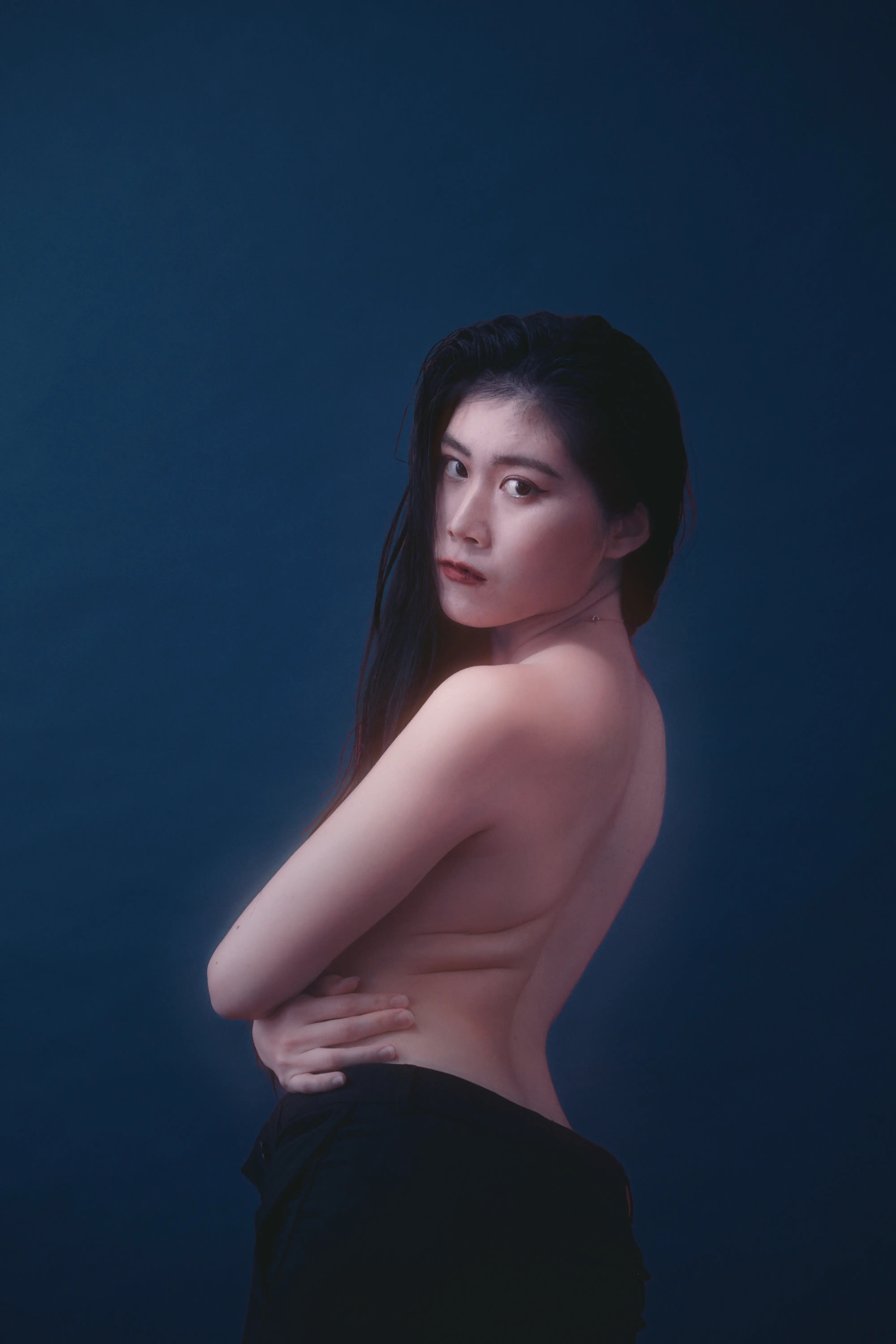 Emotionales Portrait einer Frau vor blauem Hintergrund im Fotostudio Frankfurt mit natürlichem weichem Licht, soft glow