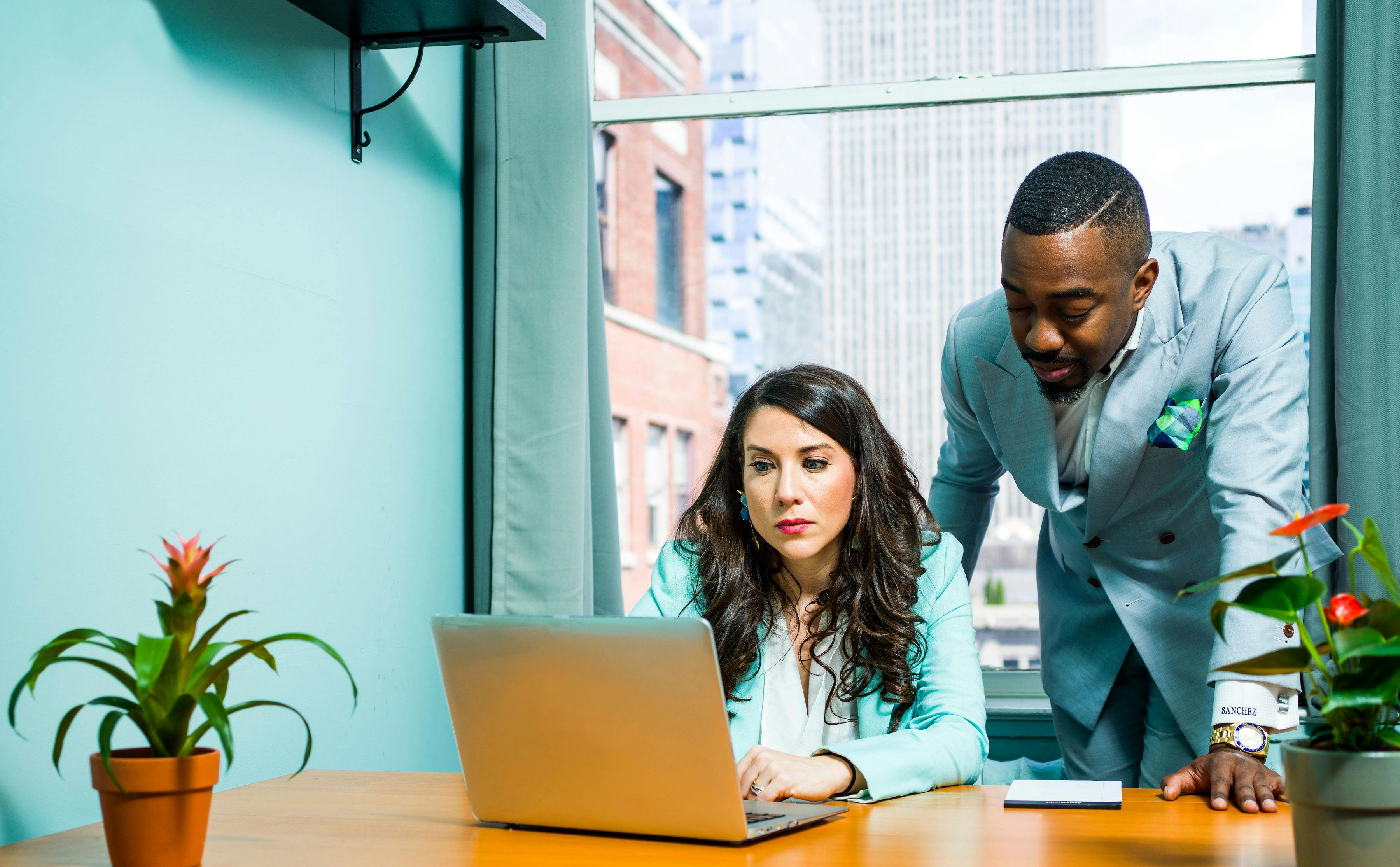 Man wearing gray suit besides woman sending follow up cold emails