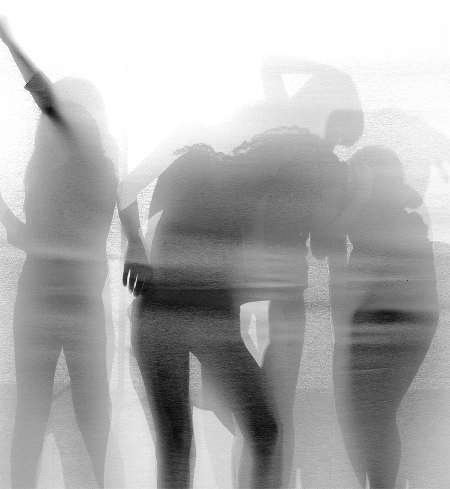 Black and white image of people working at a table with laptops, showing hands gesturing during discussion of digital content displayed on screens, with fabrica® logo in the corner.