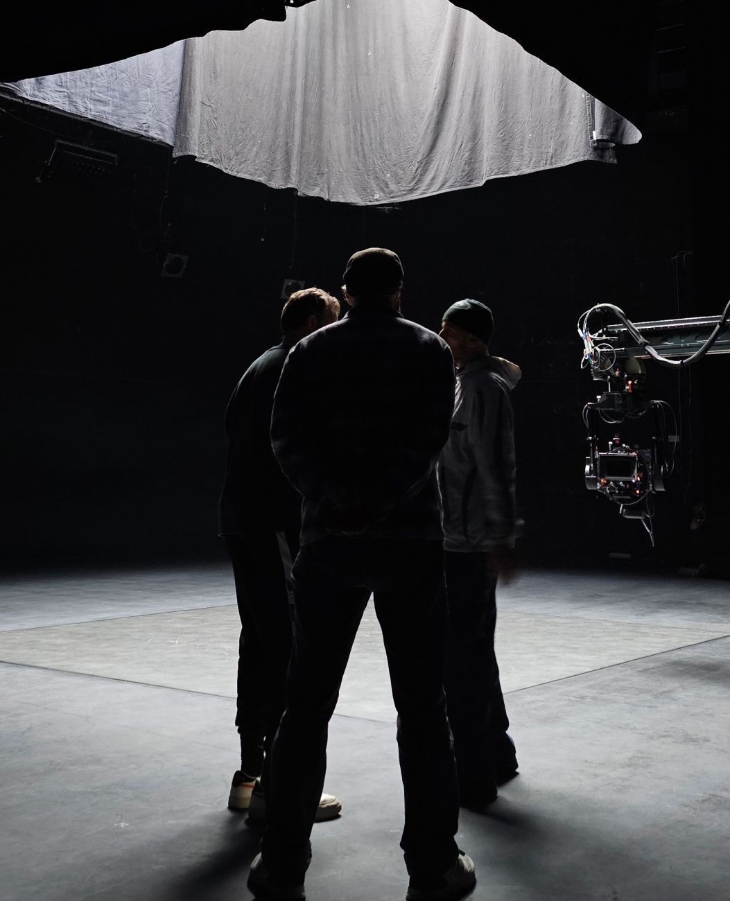 People standing and looking at an umbrella in a dark room.