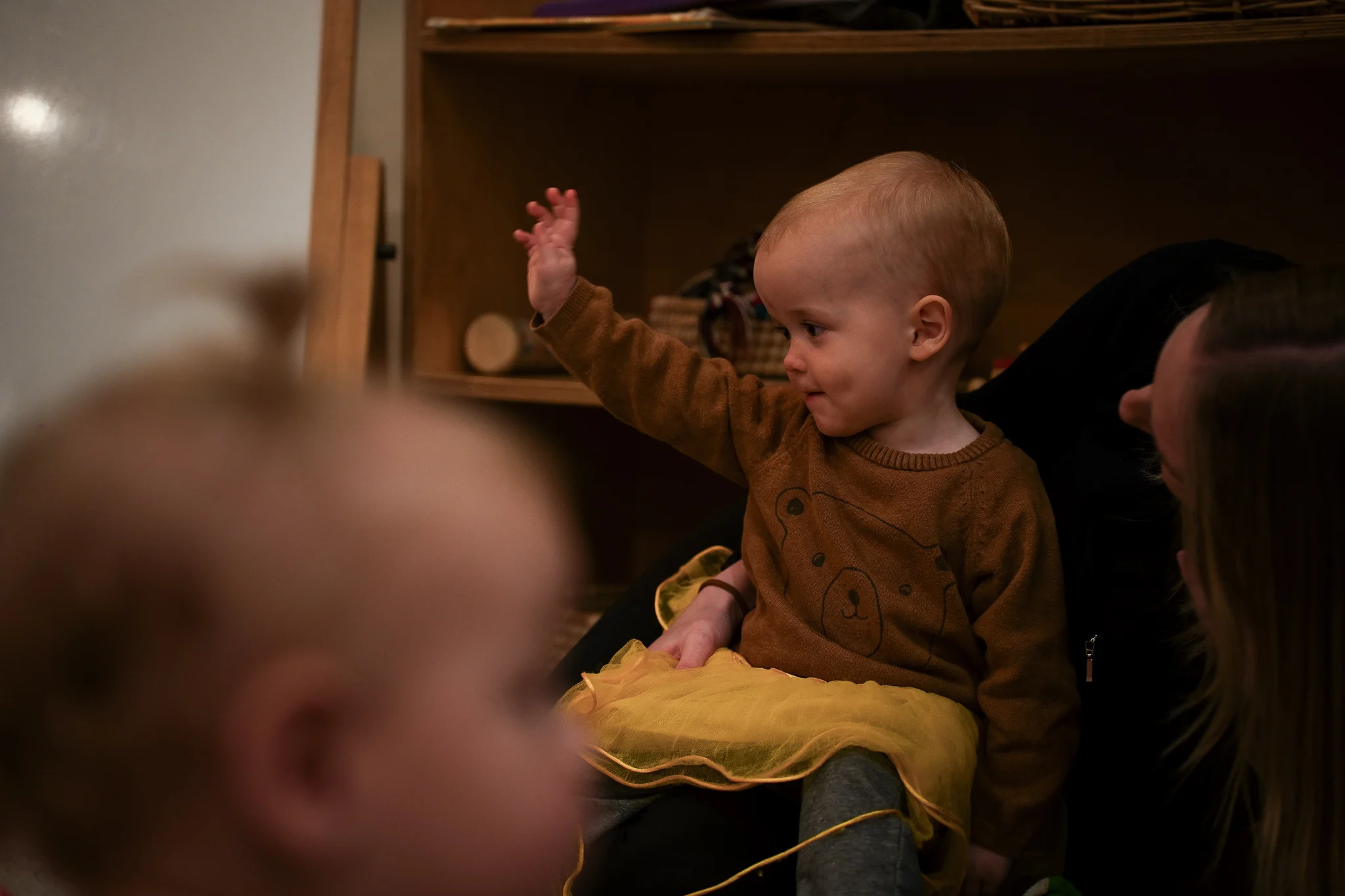 Young children engage in supervised water play with a teacher in an outdoor early childhood environment.