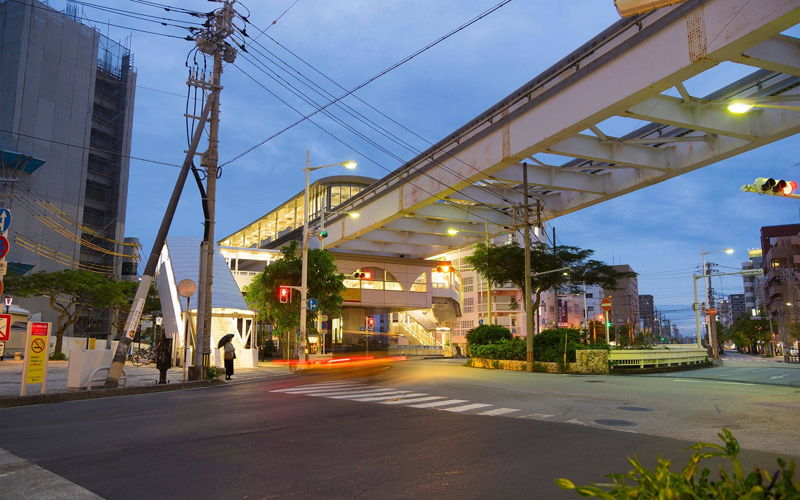 Είσοδος στο σταθμό του Μονοραϊκού Οκινάουα το σούρουπο με θέα στον δρόμο.