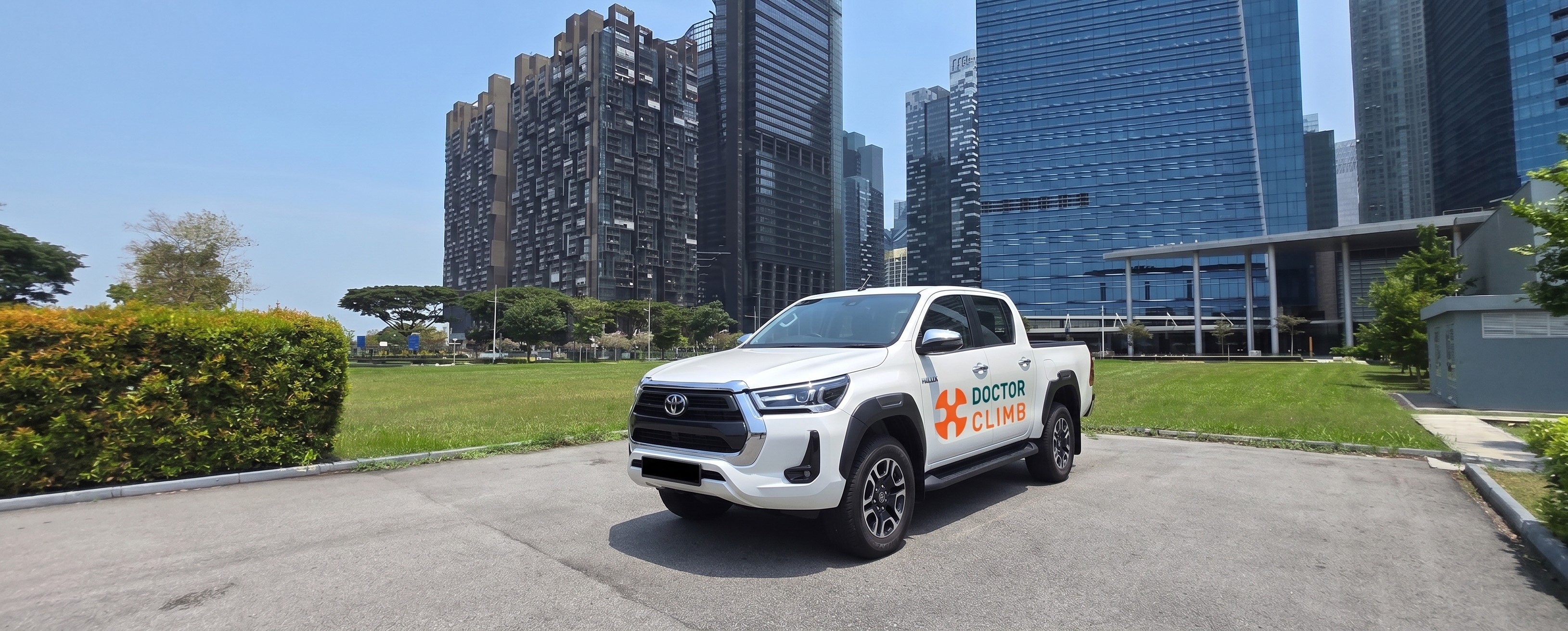Company pickup truck parked next to a Singapore city road