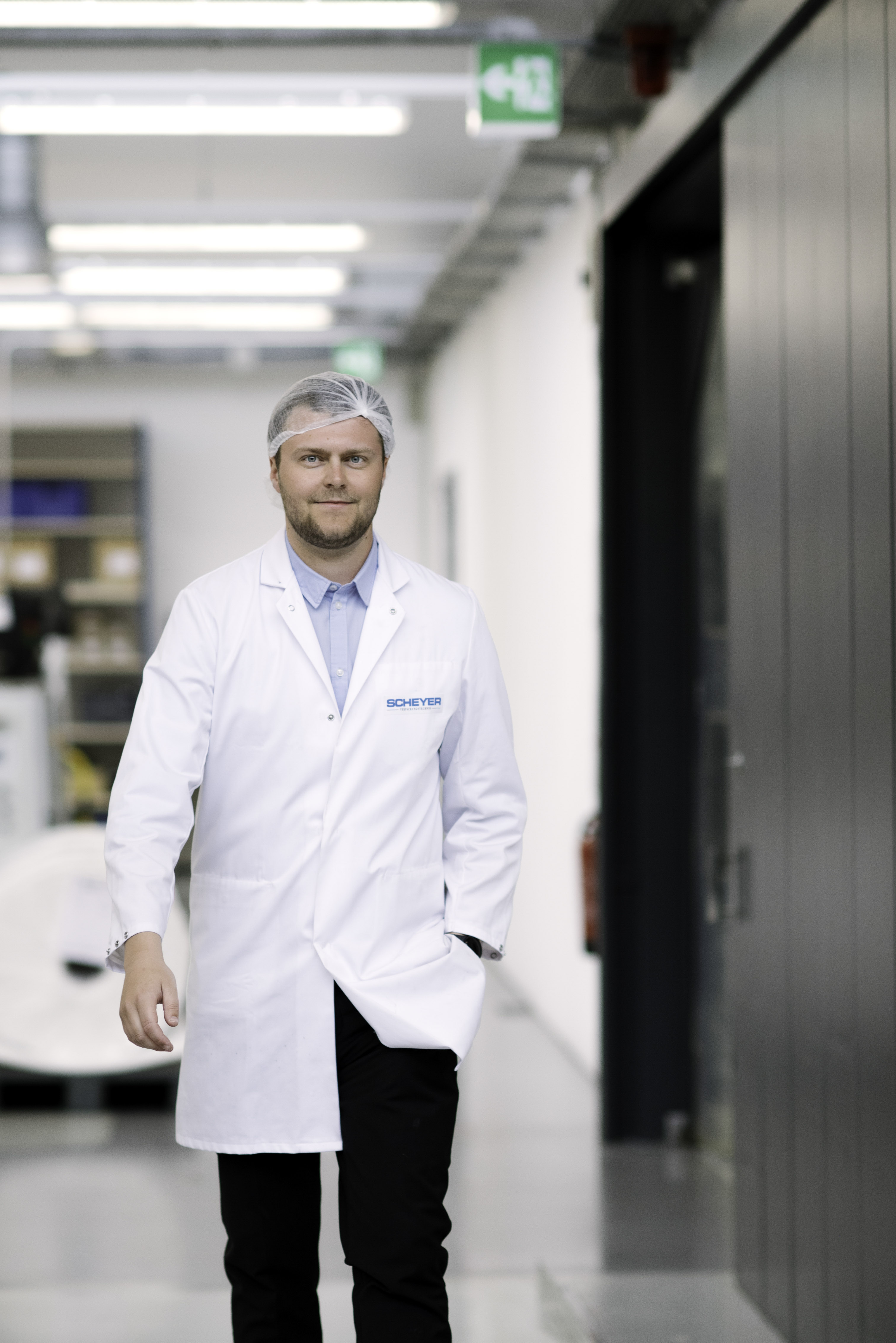 Scheyer employee in a lab coat walking through the production facility.