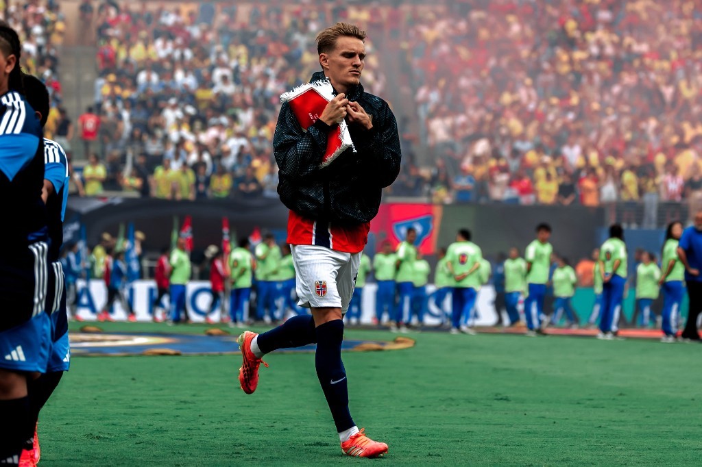 Norway captain Martin Odegaard walks onto the pitch holding the match pennant before facing Brazil in the World Cup Round of 16