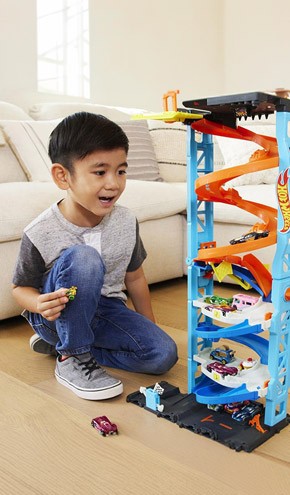 A boy playing with a car track toy