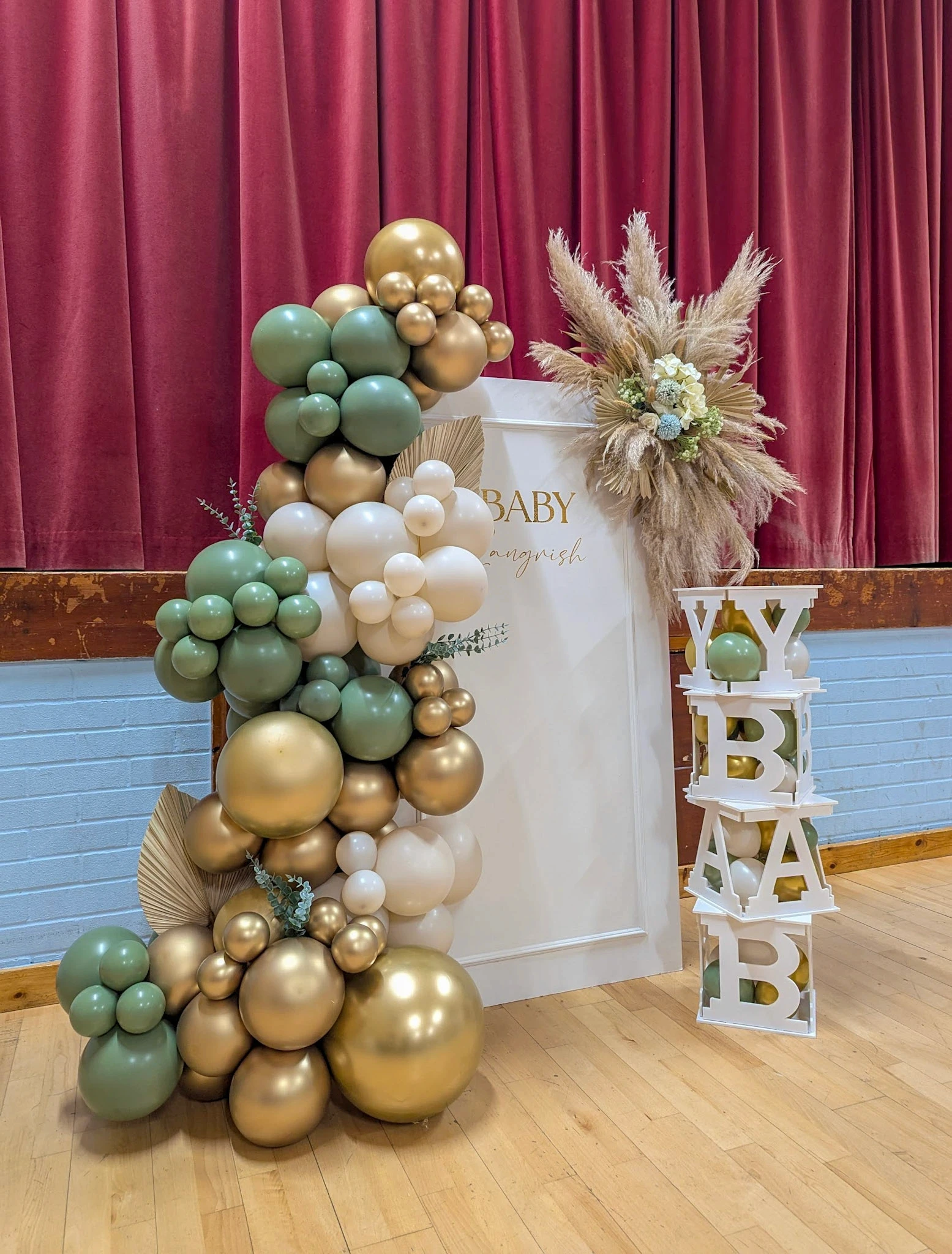 Earthy-toned balloon garland with pampas grass around wooden