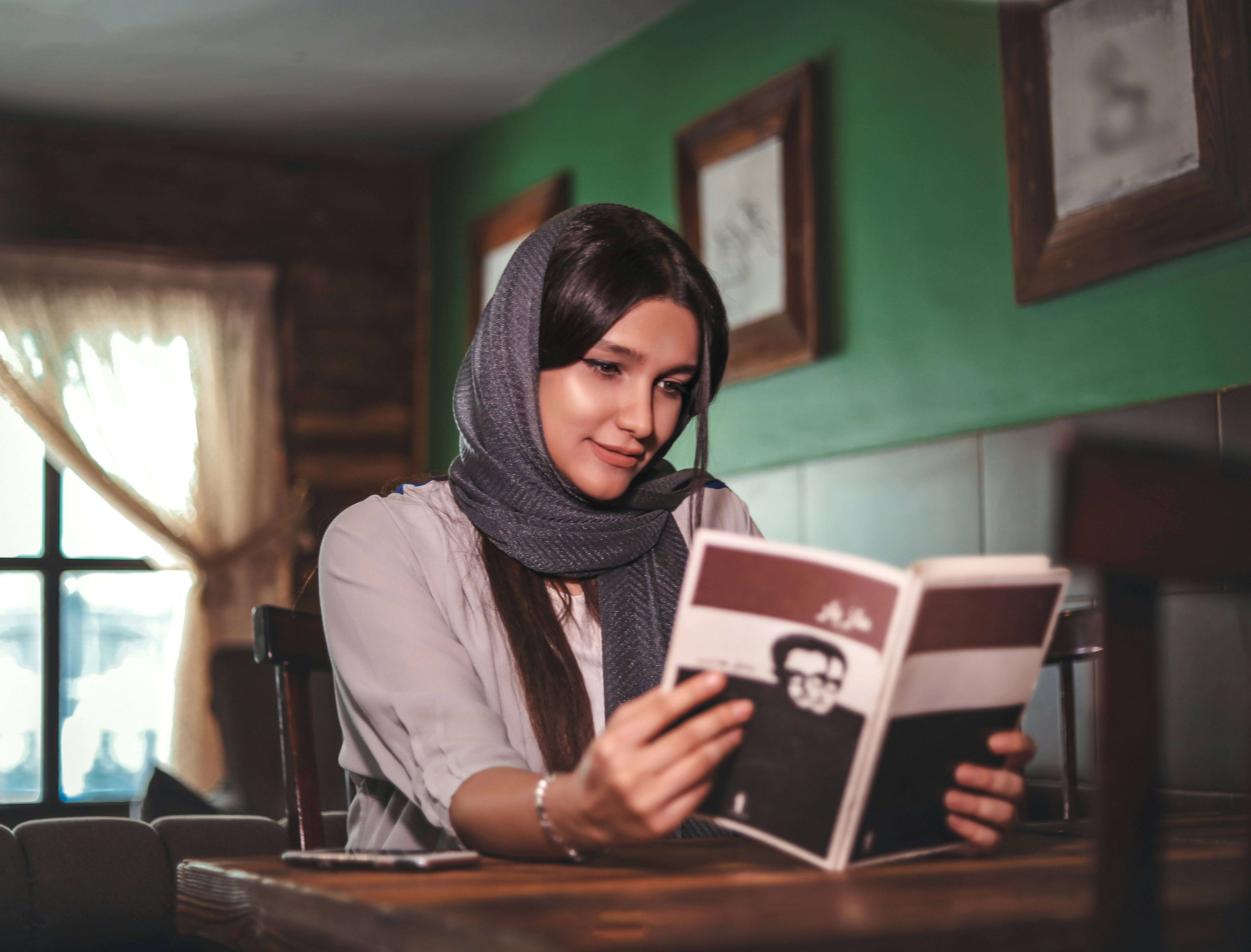 a happy woman in her house reading a book