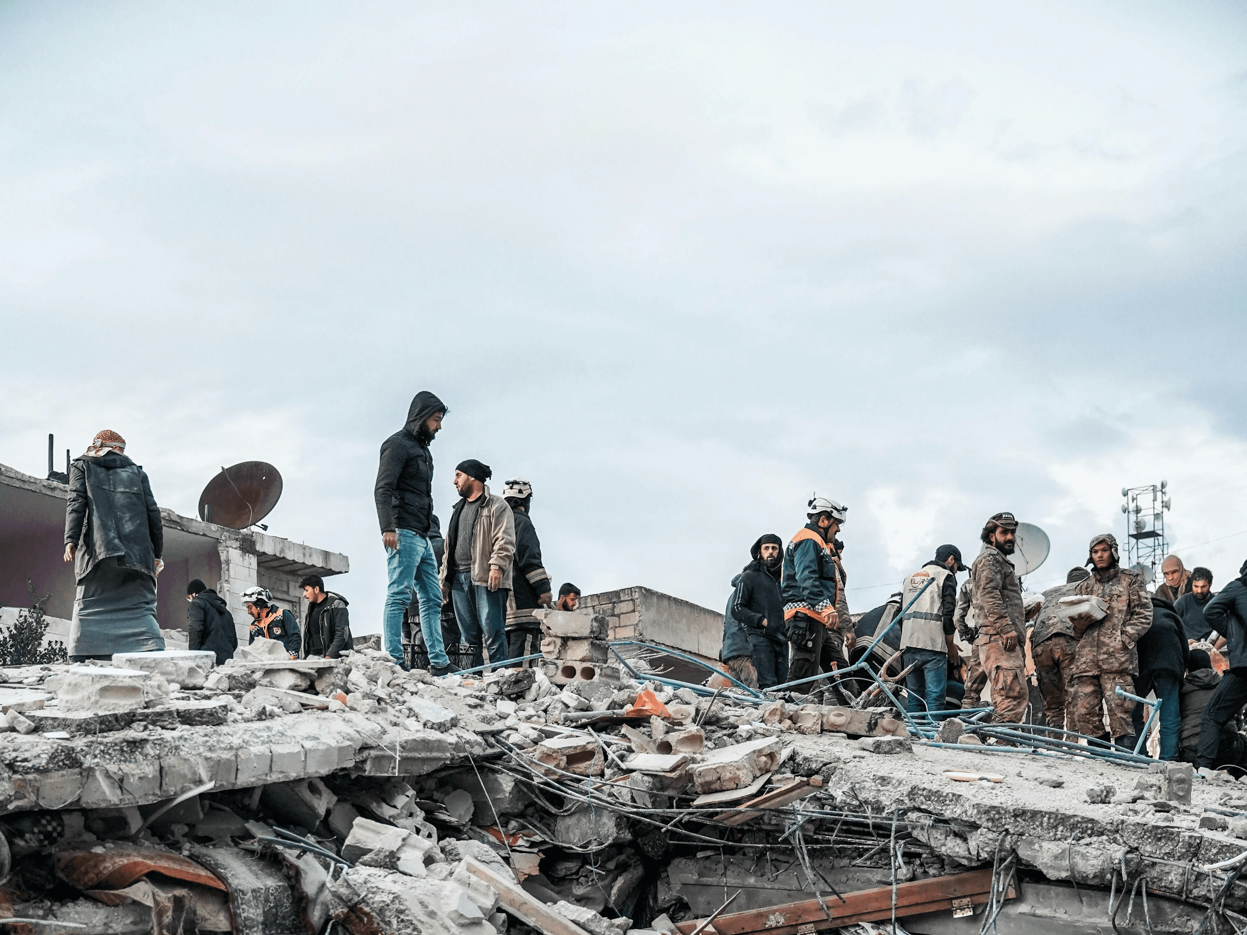 Emergency response team working at a disaster zone surrounded by debris, illustrating the importance of resilient, real-time communication powered by decentralized networks and AI-driven support during crises.