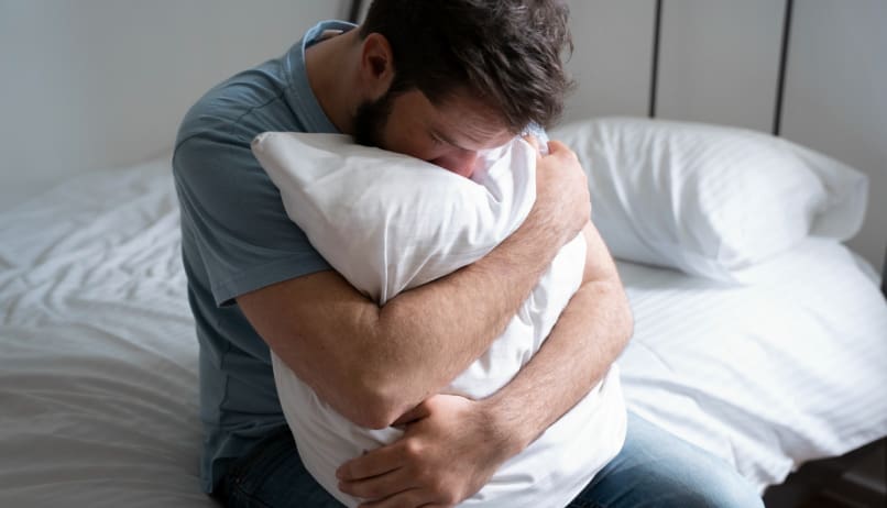 Чоловік обіймає подушку