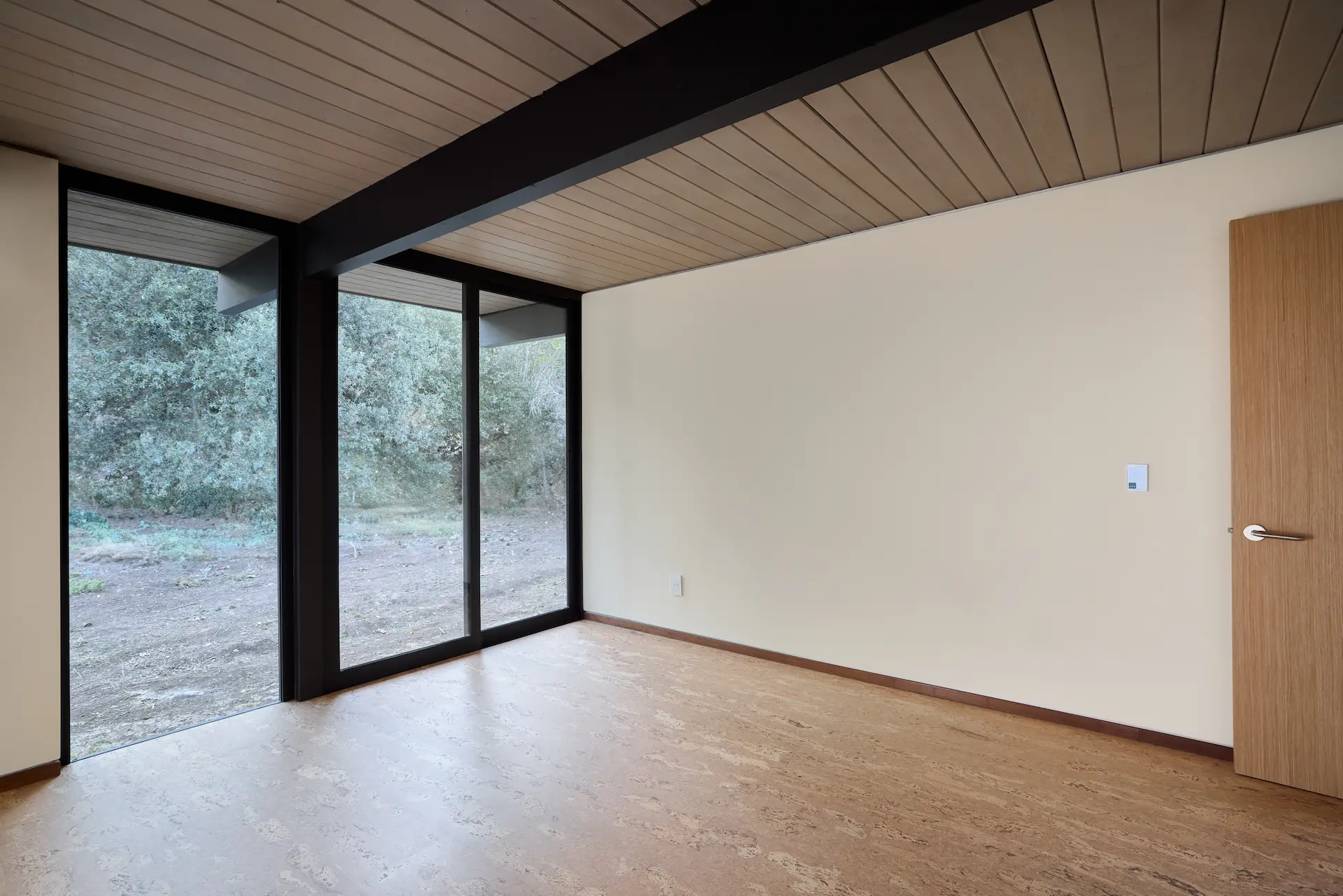 View of the master bedroom, highlighting the blend of modern finishes and historical Eichler style in this Orange, CA home. Photo by Todd Huge.