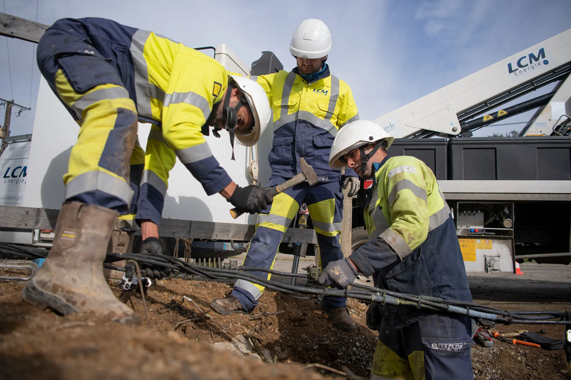 Techniciens en intervention travaux électriques souterrains pose câbles haute tension chantier