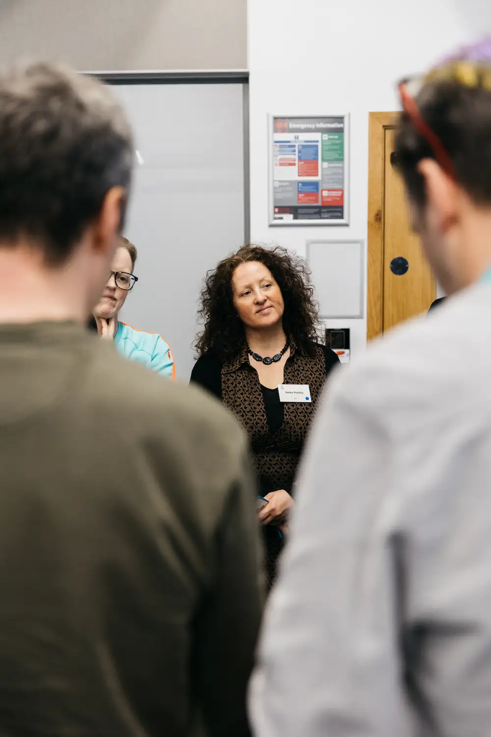People standing and talking in a hallway.