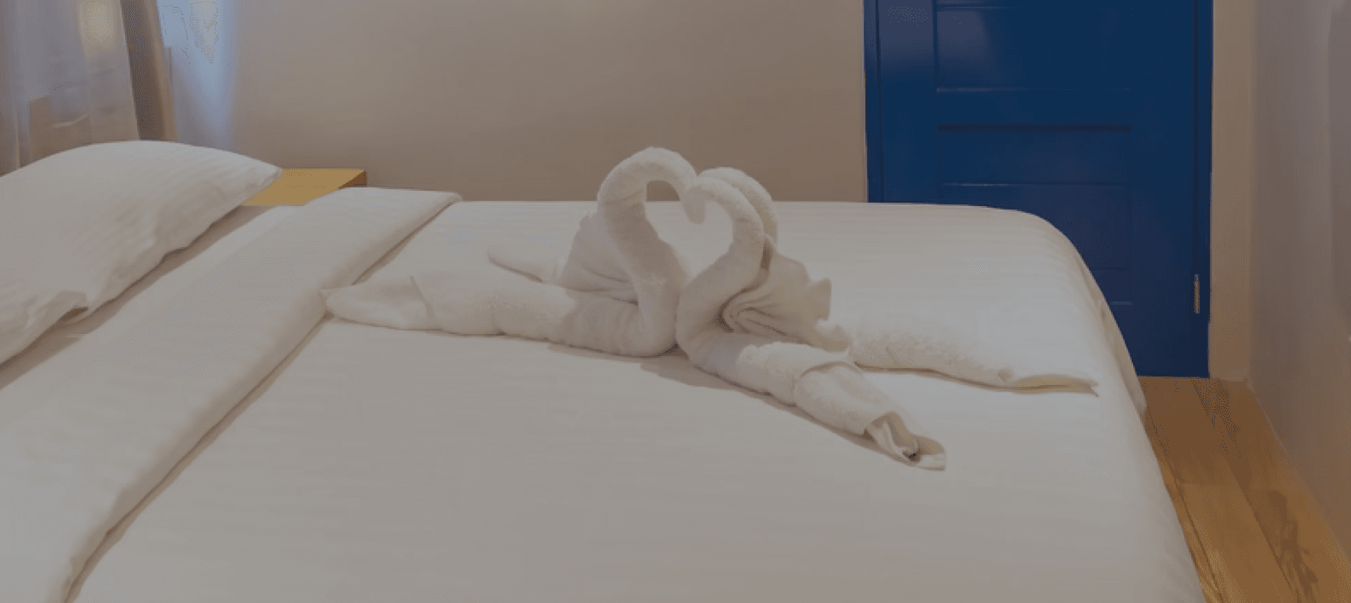 Double Room interior with signature glowing blue arched window, wooden bed and modern furnishings at Oktowaves Hotel Nasugbu