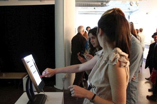 a woman pointing to an iPad's screen and looking the other way