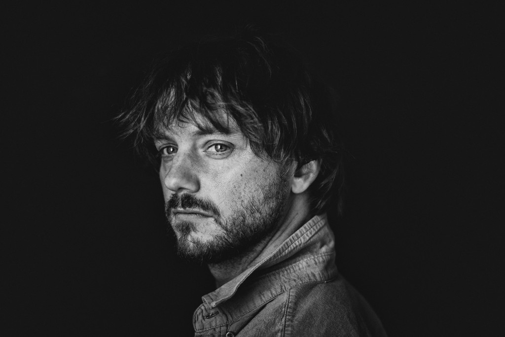 Man with beard looking over shoulder